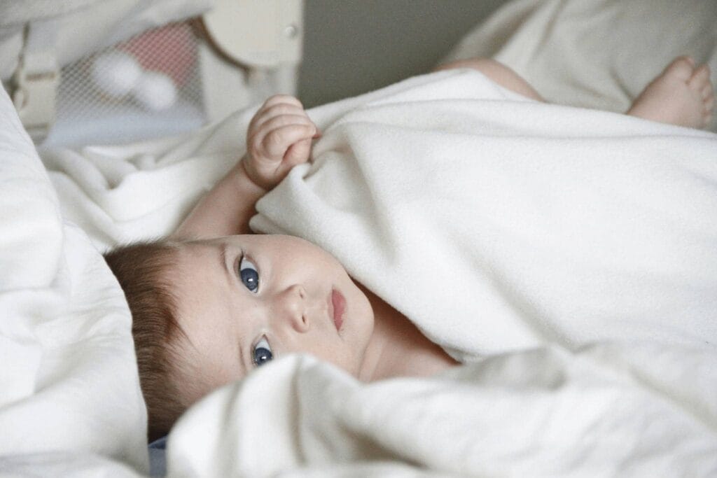 when can babies sleep with a blanket