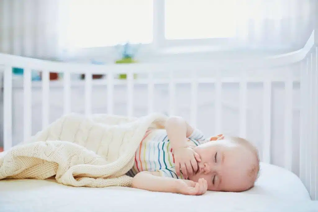 when can babies sleep with a blanket